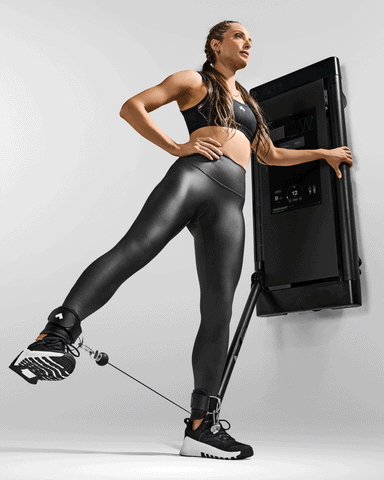 Coach Kristina Centenari performs a standing hip abduction on Tonal using ankle straps.