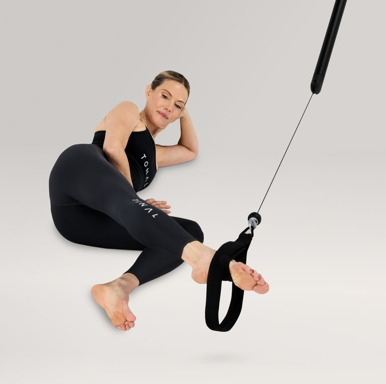 Woman doing Pilates using a Tonal Machine with Pilates loops