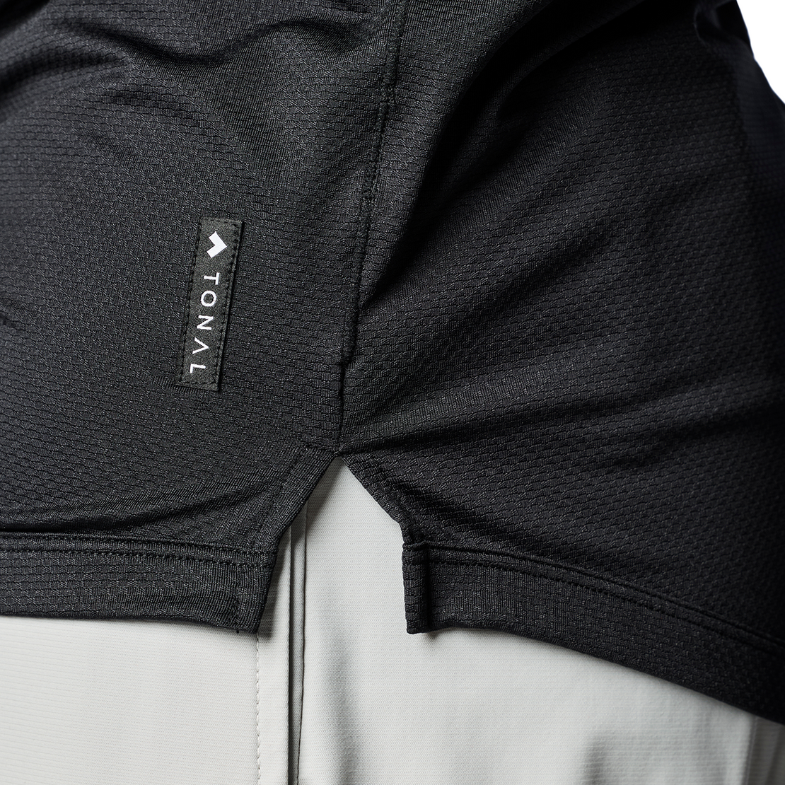 Close up of bottom hem of black Men's Tonal Performance Shop long sleeve shirt