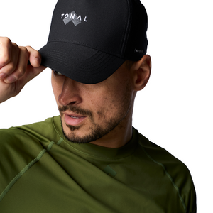 Man putting on Tonal Black baseball hat