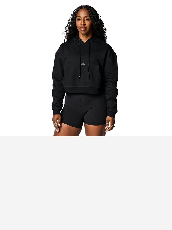 Woman wearing black cropped Tonal performance hoodie.
