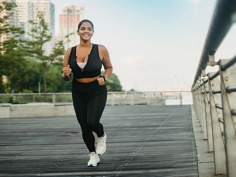 Woman running on walkway next to a river
